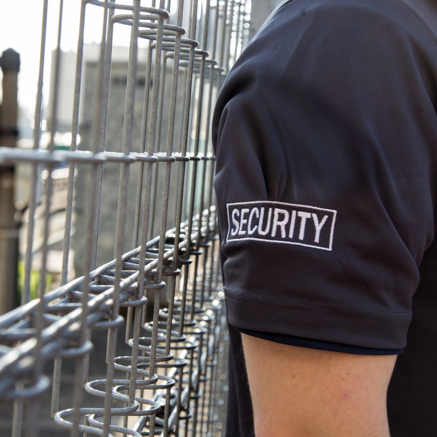 A view of a security guard in uniform patrolling a residential area nearby railway.